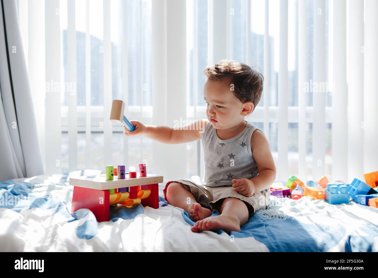 Nettes Baby Kleinkind spielen mit Lernen mehrfarbige Spielzeug Stampfbank zu Hause. Zählen Sie das Lernen. Frühes Alter Montessori Ausbildung. Kinder Hand Gehirn Stockfoto