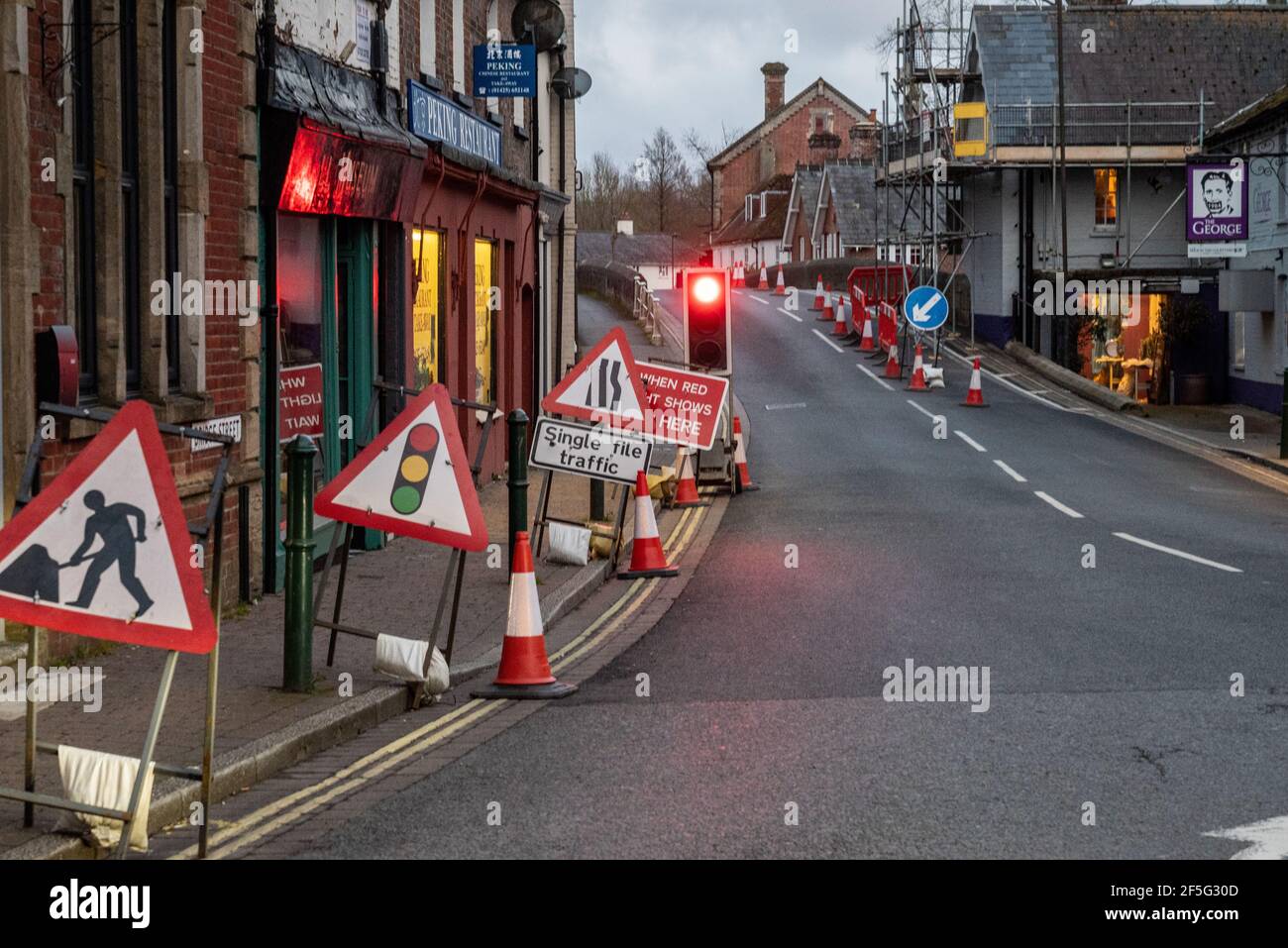 Straßenarbeiten mit Verkehrskontrolle und Ampel auf rot in Eine Straße im Stadtzentrum in Großbritannien Stockfoto