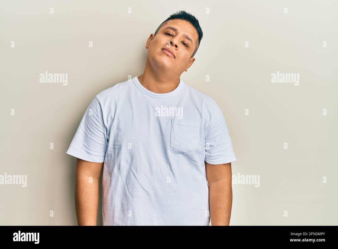 Junger latein Mann trägt lässige weiße T-Shirt entspannt mit ernster  Ausdruck im Gesicht. Einfach und natürlich Blick auf die Kamera  Stockfotografie - Alamy