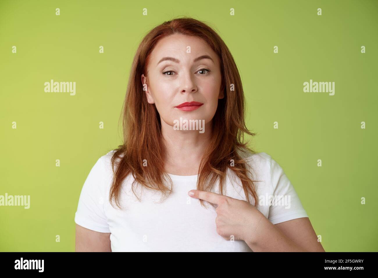 Stolze Mutter zeigt sich. Motivierte selbstbewusste Rotschopf durchsetzungsfähige Frau mittleren Alters zeigt Brust Freiwilligenarbeit prahlen eigenen Fähigkeiten Errungenschaften Stockfoto