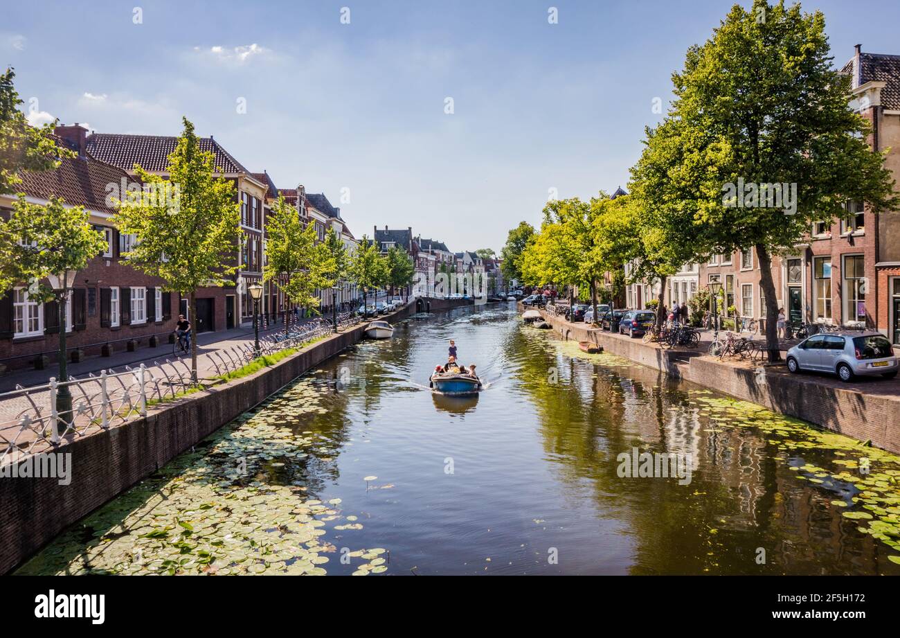 LEIDEN, NIEDERLANDE - 27. JUNI 2018: Kanäle in Leiden, Niederlande. Boot mit Menschen auf dem Kanal am Sommertag. Stockfoto