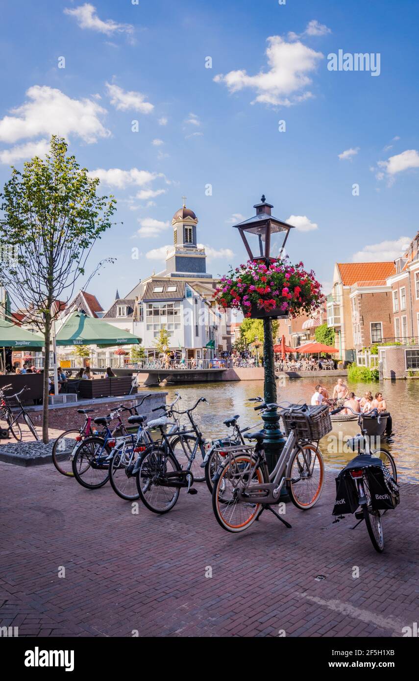 LEIDEN, NIEDERLANDE - 27. JUNI 2018: Radschar am Kanal und alte Laterne mit Blumen in Leiden, Niederlande Stockfoto