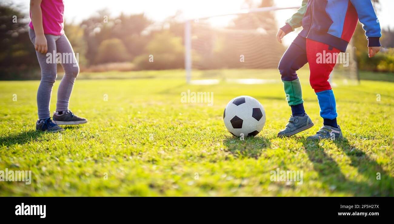 Kinder spielen Fußball auf dem Feld mit Toren. Stockfoto