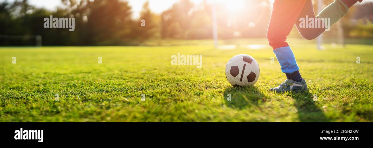 Kind spielt Fußball auf dem Feld mit Toren. Stockfoto
