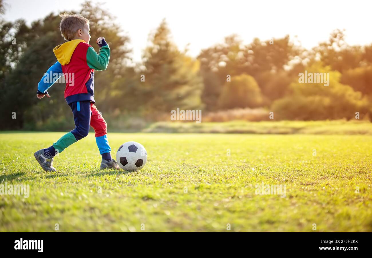 Kind spielt Fußball auf dem Feld mit Toren. Stockfoto