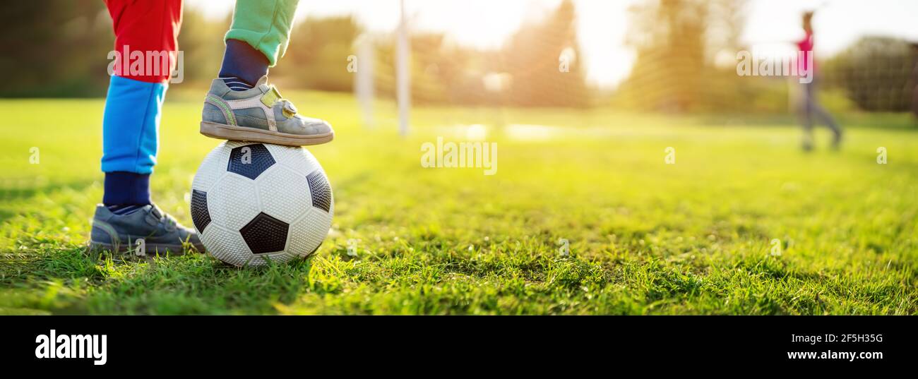 Kinder spielen Fußball auf dem Feld mit Toren. Stockfoto