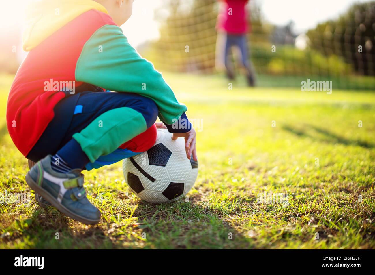 Kinder spielen Fußball auf dem Feld mit Toren. Stockfoto