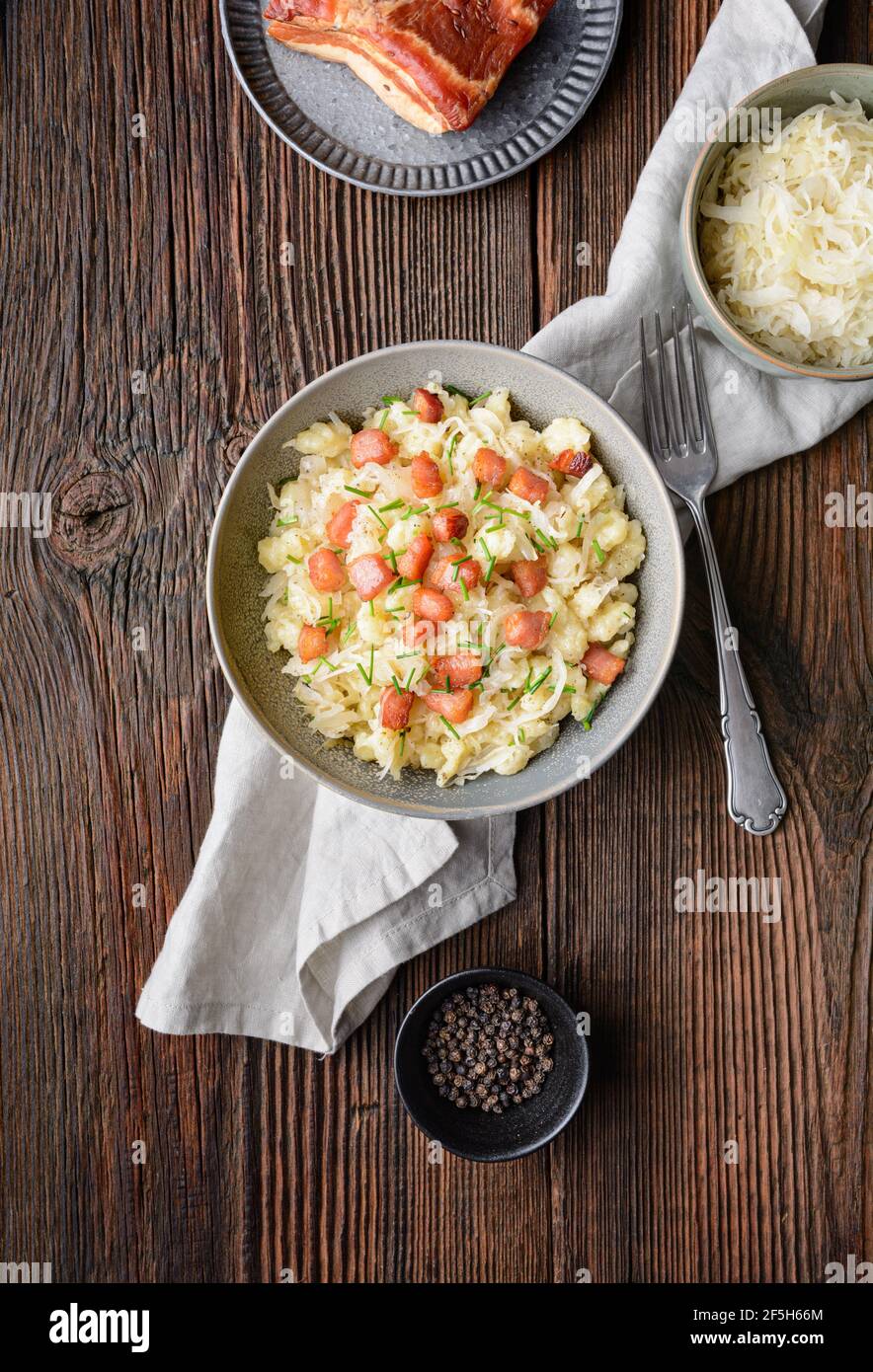 Kapustove halusky bekannt als Strapacky, klassisches Gericht in der Slowakei, gekochte Kartoffelknödel mit Sauerkraut und Zwiebel, gekrönt mit gebratenem Speck und frischem c Stockfoto