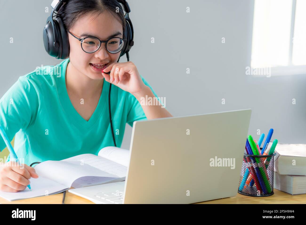 Asiatische Frau suchen zu sprechen Videokonferenz anrufen auf ein Laptop-Computer Mädchen Studenten sprechen reagieren mit Headset-Mikrofon-Klasse universität lernen Stockfoto