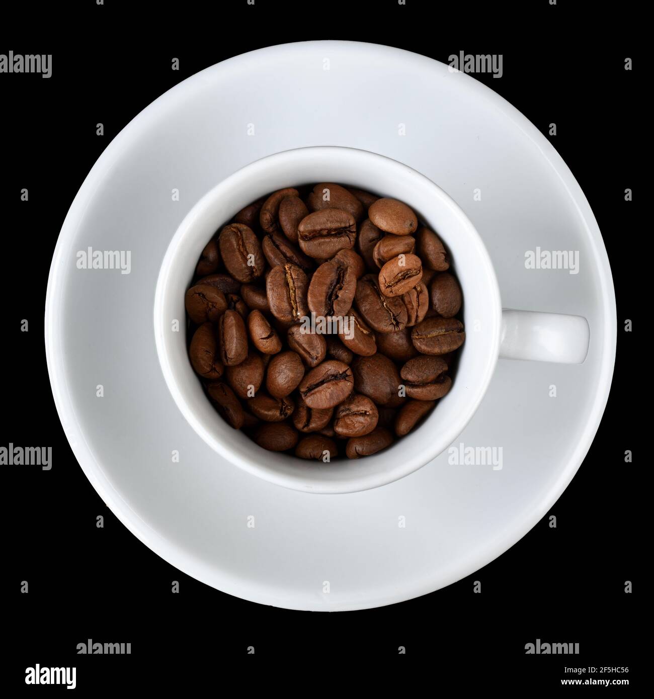 Tasse heißen Kaffee mit einer Streuung von Kaffeebohnen isoliert auf einem schwarzen Hintergrund. Stockfoto