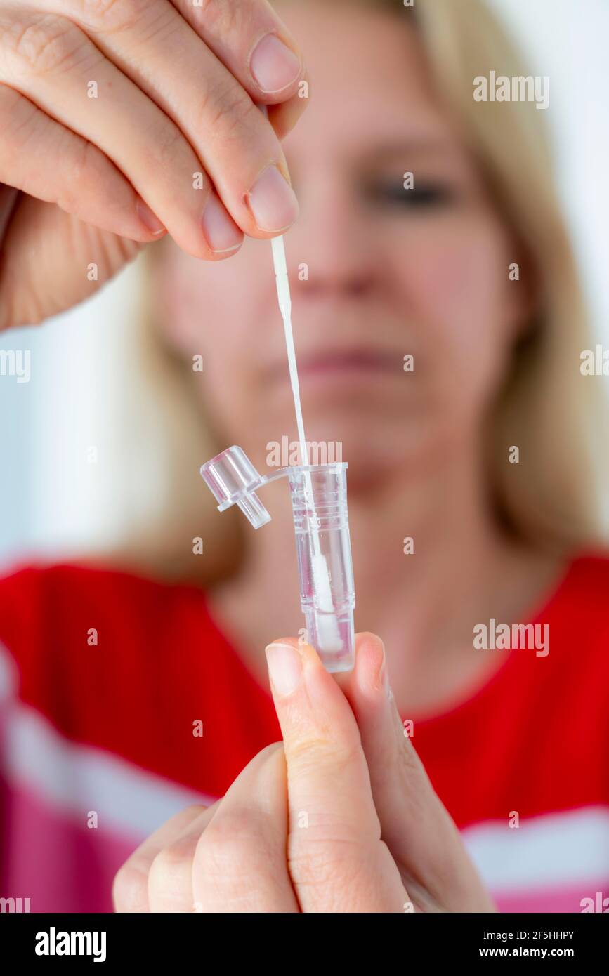 Corona Antigen Schnelltest, Laientest, Selbsttest, zum Nachweis von SARS-CoV-2 Infektion, Nasenabstrich, im Reagenzglas auflösen, Stockfoto