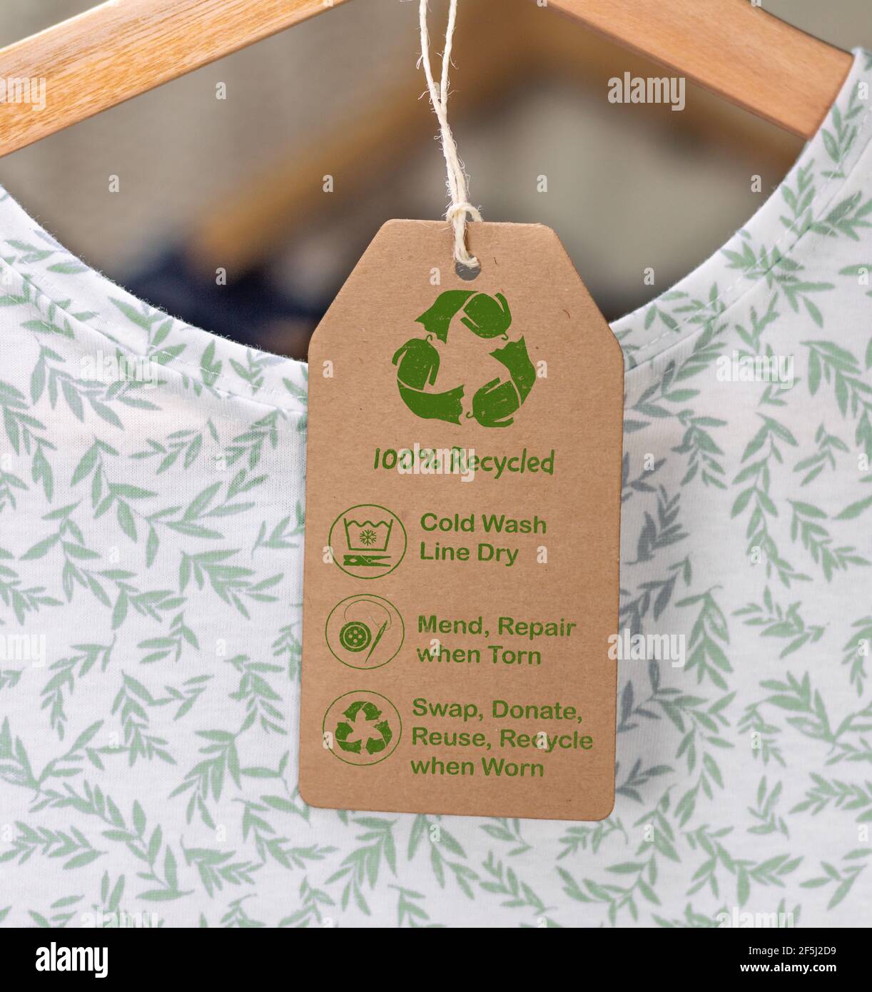 Recycling-Pflegeetikett auf T-Shirt, nachhaltige Mode kalt waschen, Linie trocken, reparieren und reparieren, wiederverwenden, tauschen oder spenden mit Symbolen. Stockfoto