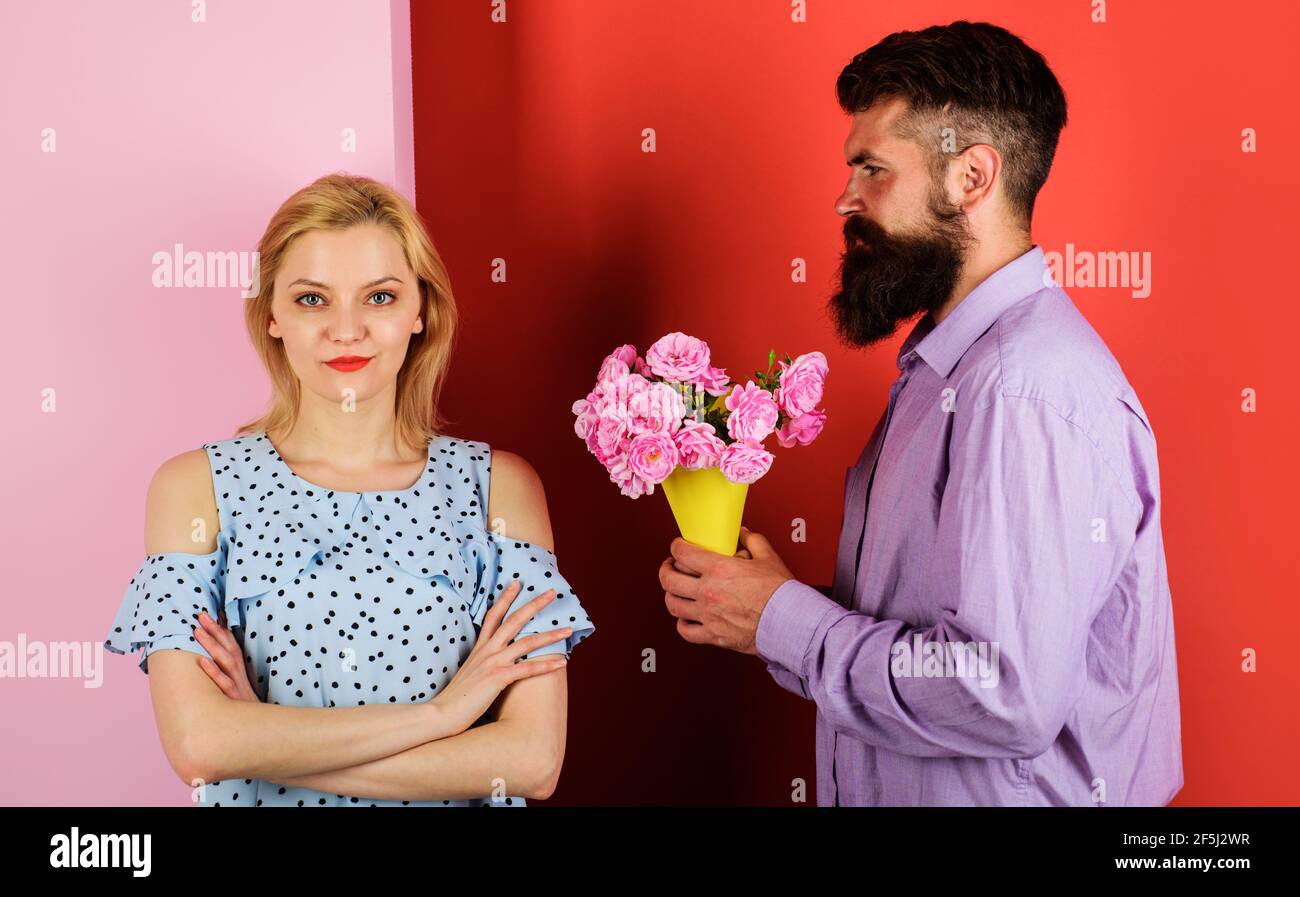 Wunderschönes romantisches Paar. Freund mit Blumen für Freundin. Schöner bärtiger Mann mit Strauß Rosen für die Frau. Stockfoto