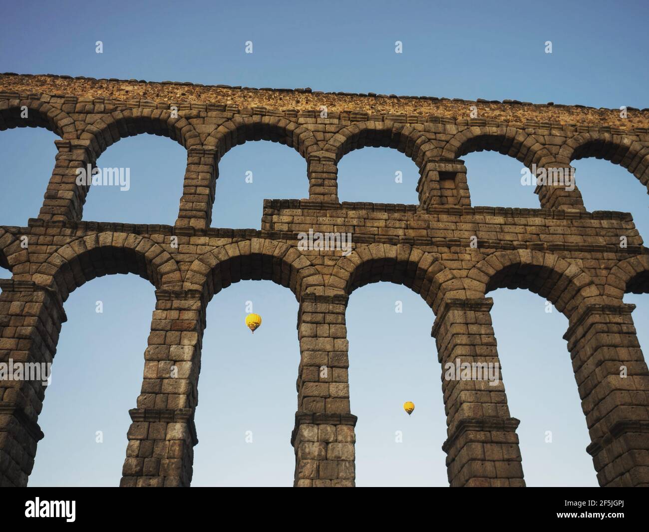 Heißluftballons hinter Aquädukt von Segovia römische Architektur Stein Felsbogen Viadukt Brücke in Kastilien und Leon, Spanien Europa Stockfoto