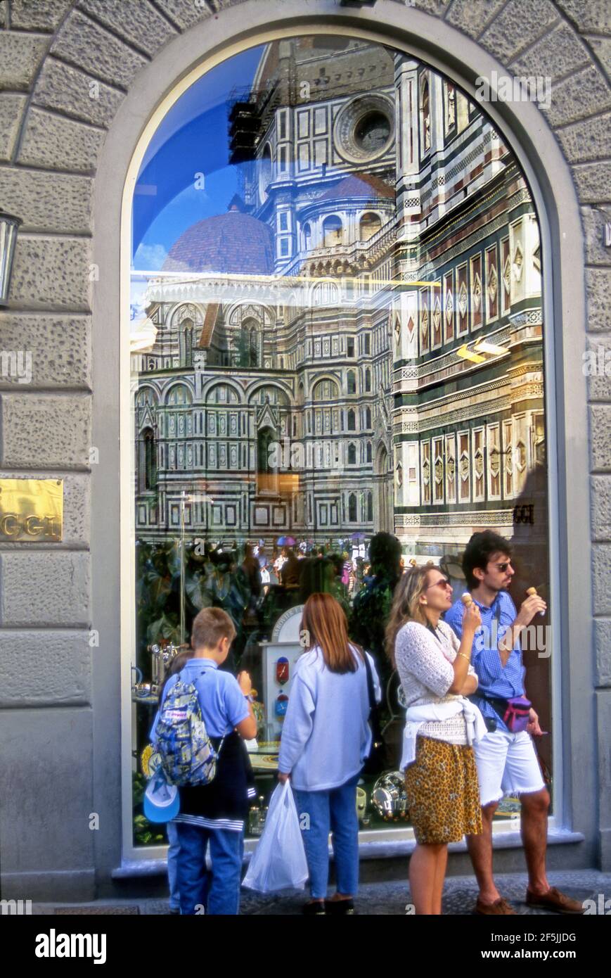 Familie im Urlaub genießen Gelato, während sie den Dom bewundern, der sich in Schaufenster in den Straßen von Florenz, Italien, widerspiegelt. Stockfoto