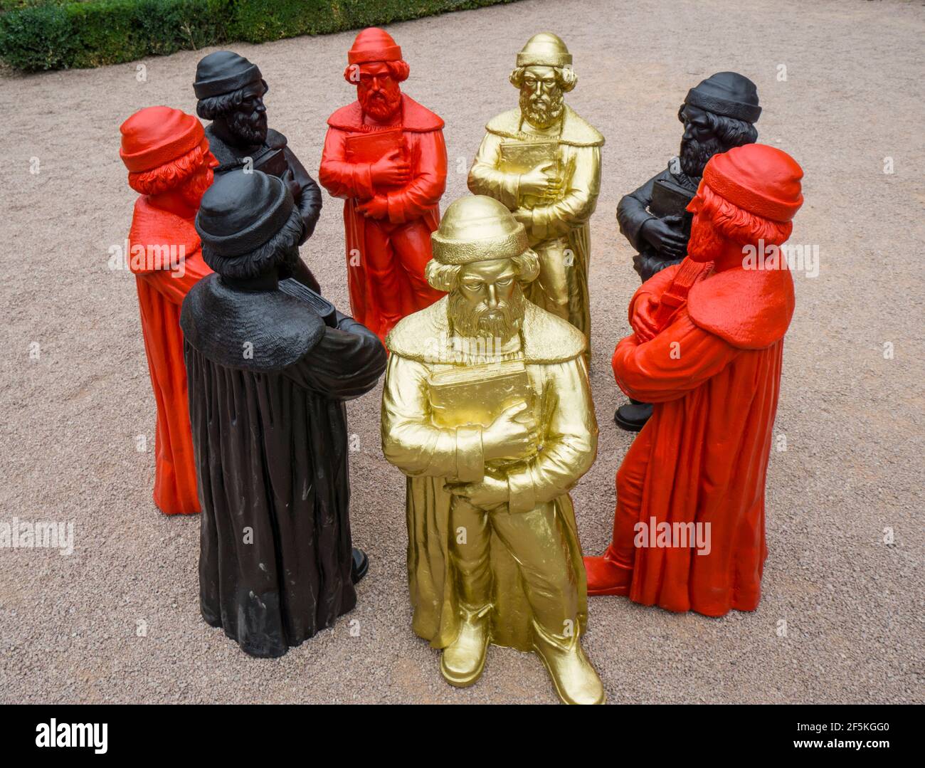 Skulpturale Installation von schwarzen, goldenen und roten Gutenberg-Statuetten von Ottmar Hörl im Rosengarten des Eltville Kurfürstliche Schlosses Stockfoto