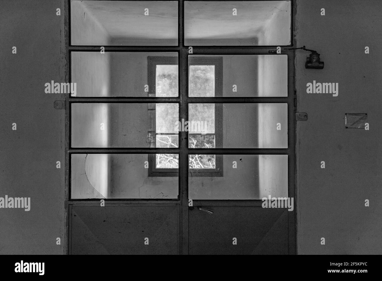 Im Inneren eines verlassenen dunklen Gebäudes kommt nur wenig Licht durch das Fenster Stockfoto