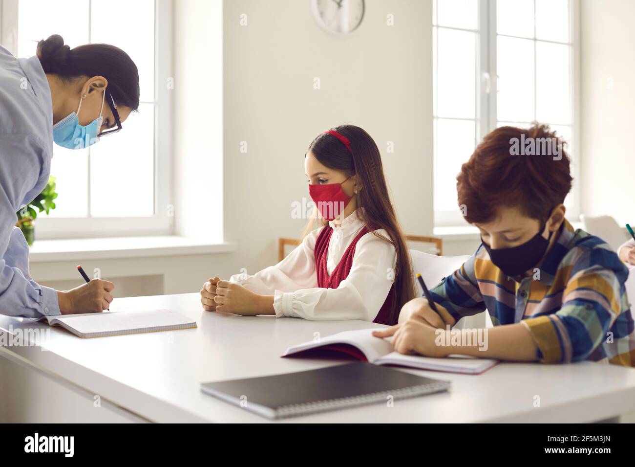 Lehrer und Schüler in Schutzmaske auf Offline-Unterricht Im Klassenzimmer Stockfoto