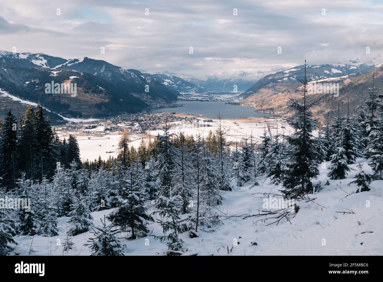 Zell am See mit dem Zeller See, eine alpine Winterlandschaft mit verschneiten Bergen in Salzburg, Österreich Stockfoto