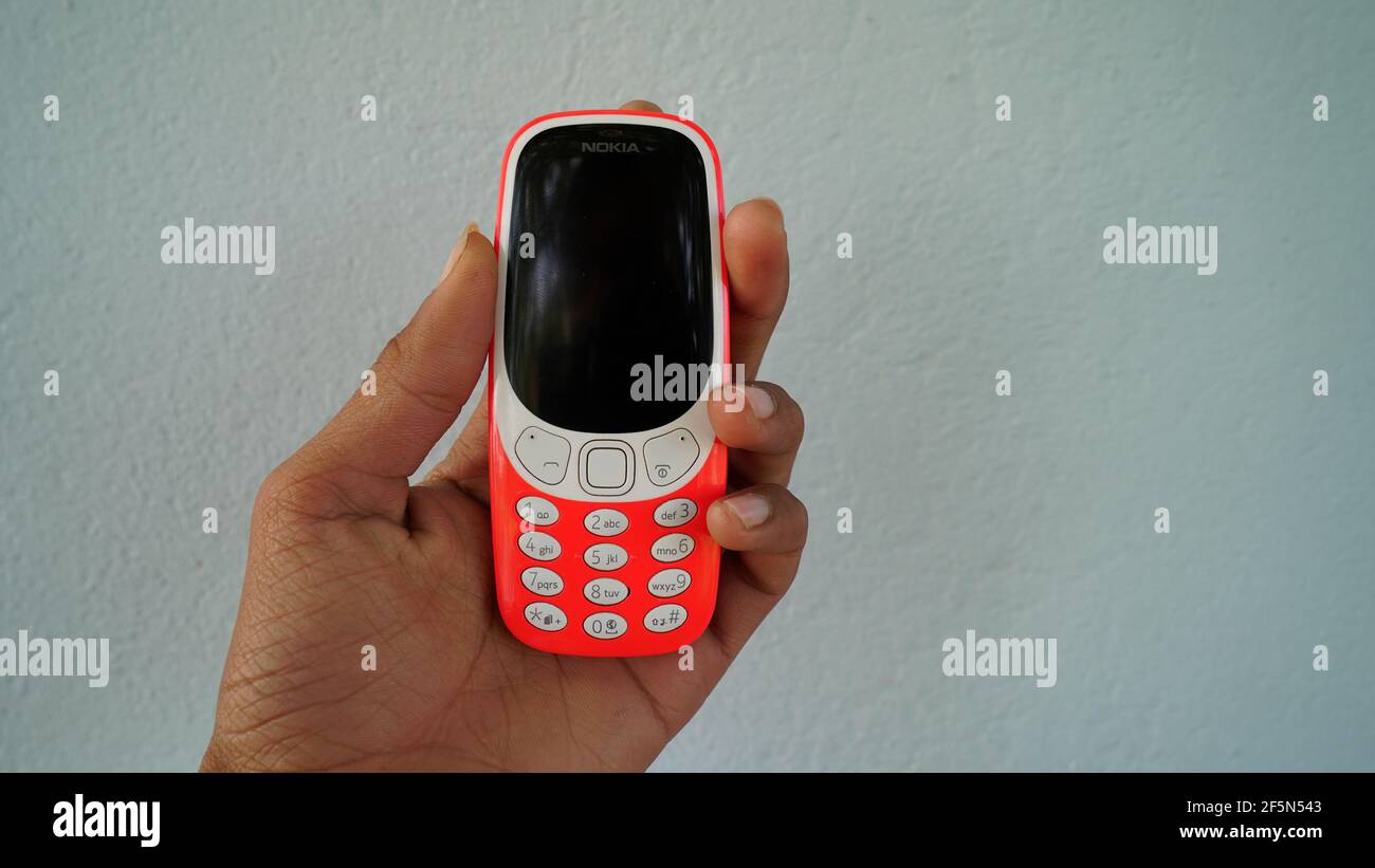 Rajasthan, Indien - 20. März 2021; EIN Mann hält Nokia Tastatur mobile Modell 3310 mit schwarzem Bildschirm isoliert auf weißem Hintergrund. Smartphone-Taste I drücken Stockfoto