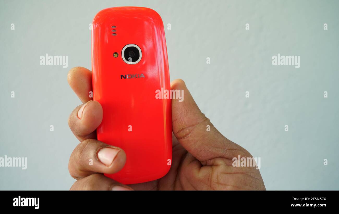 Rajasthan, Indien - 20. März 2021; EIN Mann hält Nokia Tastatur mobile Modell 3310 mit schwarzem Bildschirm isoliert auf weißem Hintergrund. Smartphone-Taste I drücken Stockfoto