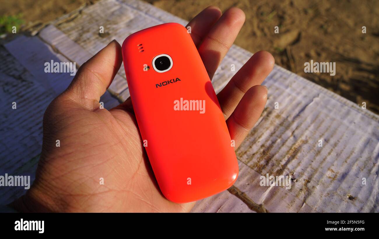 Rajasthan, Indien - 20. März 2021; EIN Mann hält Nokia Tastatur mobile Modell 3310 mit schwarzem Bildschirm isoliert auf weißem Hintergrund. Smartphone-Taste I drücken Stockfoto