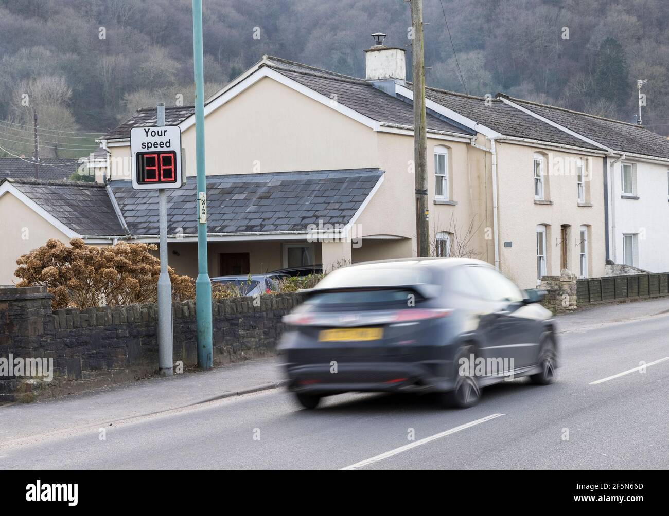 Auto, das durch Dorf auf Ihrem Geschwindigkeit digitalen Zeichen in 30mph Limit gefangen, Llanfoist, Wales, Großbritannien Stockfoto