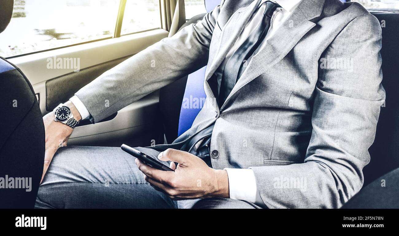 Junger, hübscher Geschäftsmann, der im Taxi sitzt und SMS schreibt Mit Smartphone - Business-Konzept mit modernem Mann mit smart Telefon Stockfoto