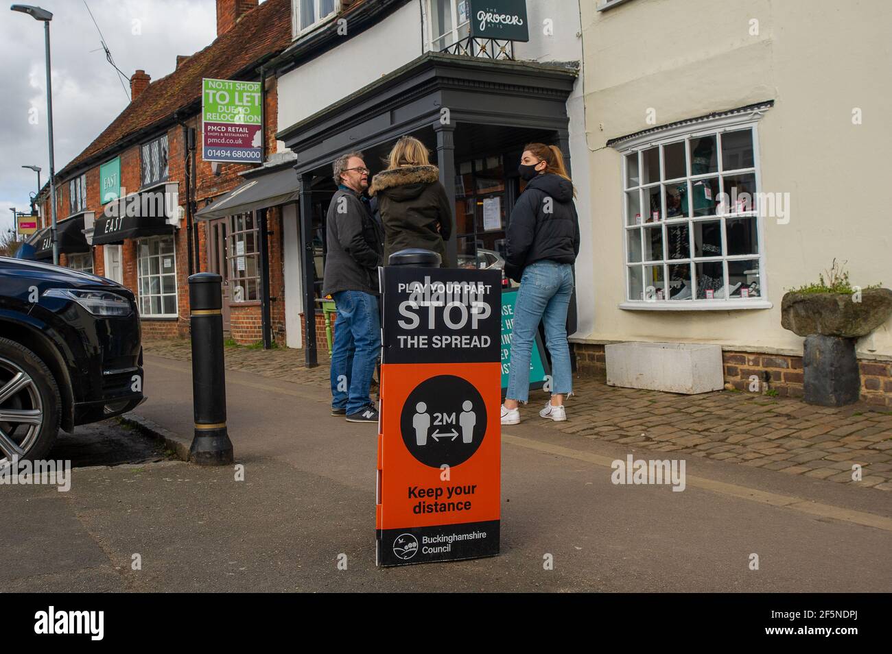 Old Amersham, Buckinghamshire, Großbritannien. März 2021, 27th. Es war ein geschäftiger Morgen in Old Amersham heute, als die Leute draußen das wärmere Wetter genossen und für Kaffee zum Mitnehmen Schlange standen, während andere die Farben der Frühlingsblumen in den Old Amersham Memorial Gardens genossen. Einige der Covid-19-Sperrbeschränkungen werden am Montag nächste Woche aufgehoben, was viele alarmiert, da sie befürchten, dass die Zahl der Covid-19-Fälle dadurch wieder steigen wird. Quelle: Maureen McLean/Alamy Live News Stockfoto