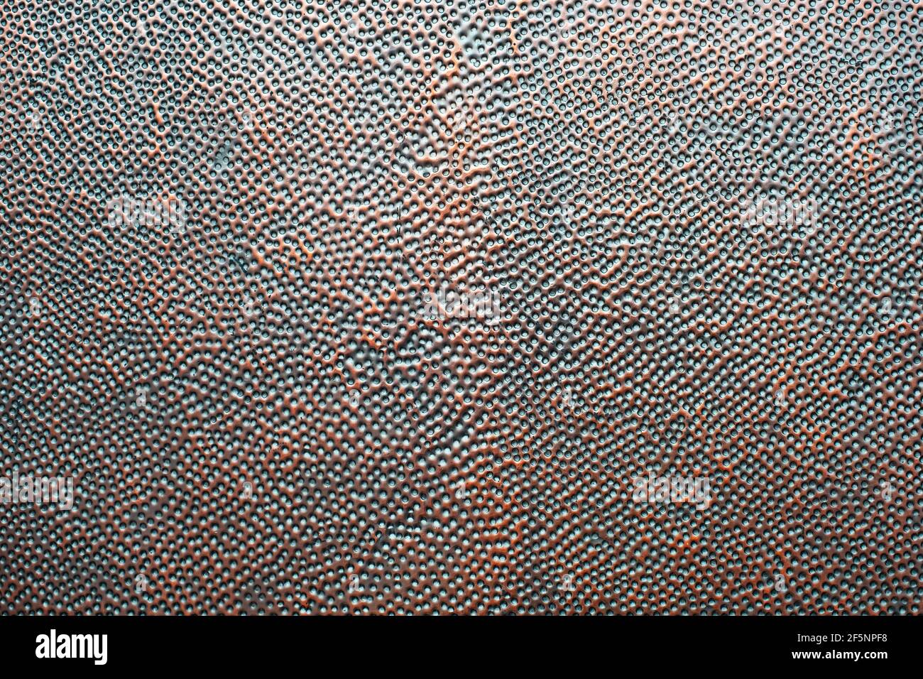 Detail von perforiertem Kupfer Metallblech. Kupferbrett mit schwarzen Löchern. Rostig alt perforierte Metallplatte Material Oberfläche Textur Hintergrund. Stockfoto