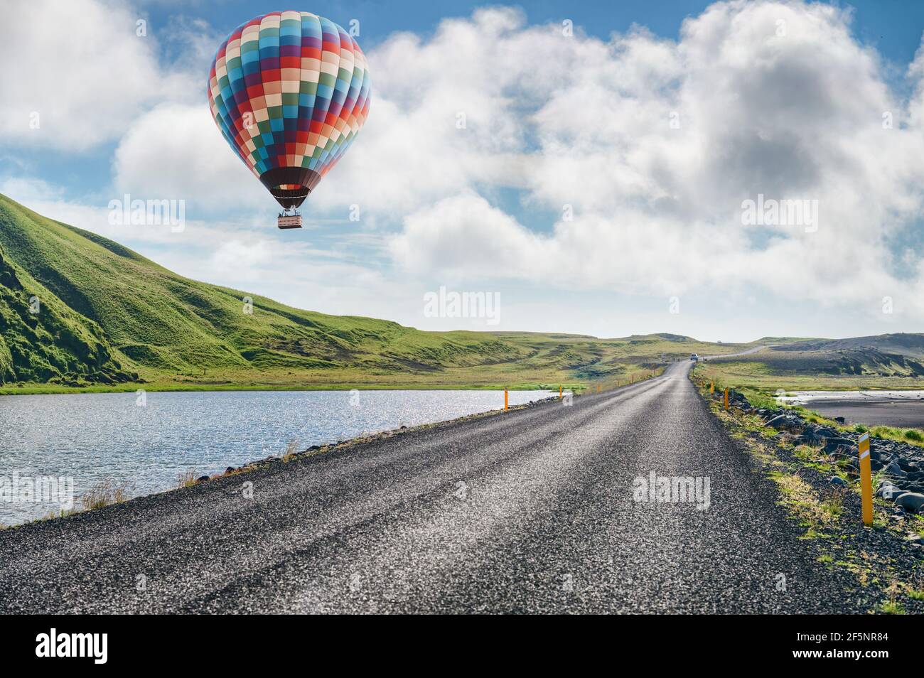 Heißluftballon über grüne Hügel und Straße in Island Stockfoto