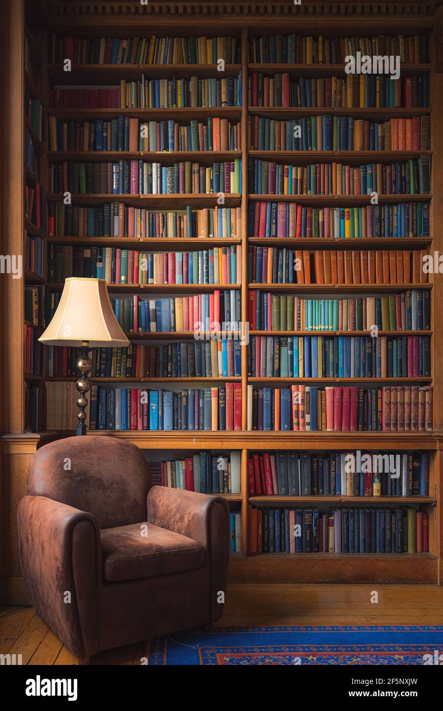 Edinburgh, Schottland - Juni 5 2019: Eine gemütliche altmodische Leseecke mit stattlichen Haus Bibliothek Sammlung von Vintage-Bücher. Stockfoto