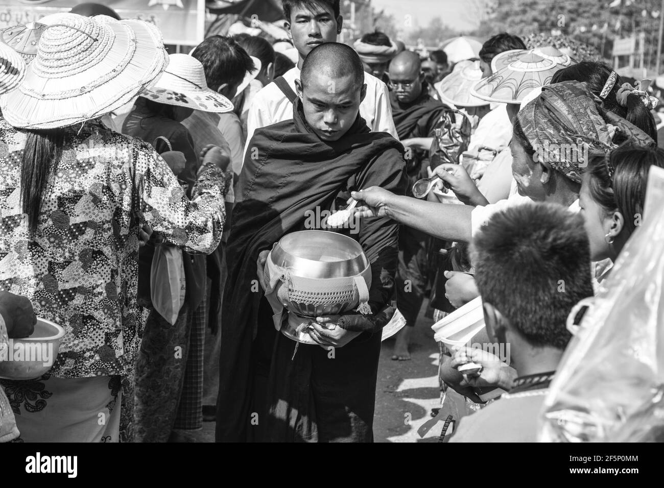 Die Mönche gehen Sie die Hauptstraße in Pindaya auf der Suche nach Almosen während des Pindaya Cave Festival, Pindaya, Shan Staat, Myanmar. Stockfoto