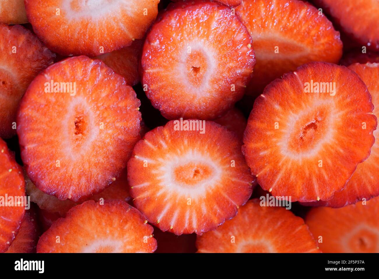 Nahaufnahme von in Scheiben geschnittenen ​​ripe-Erdbeeren. Frucht als roter Hintergrund. Gesunde Ernährung mit vielen Vitaminen Stockfoto