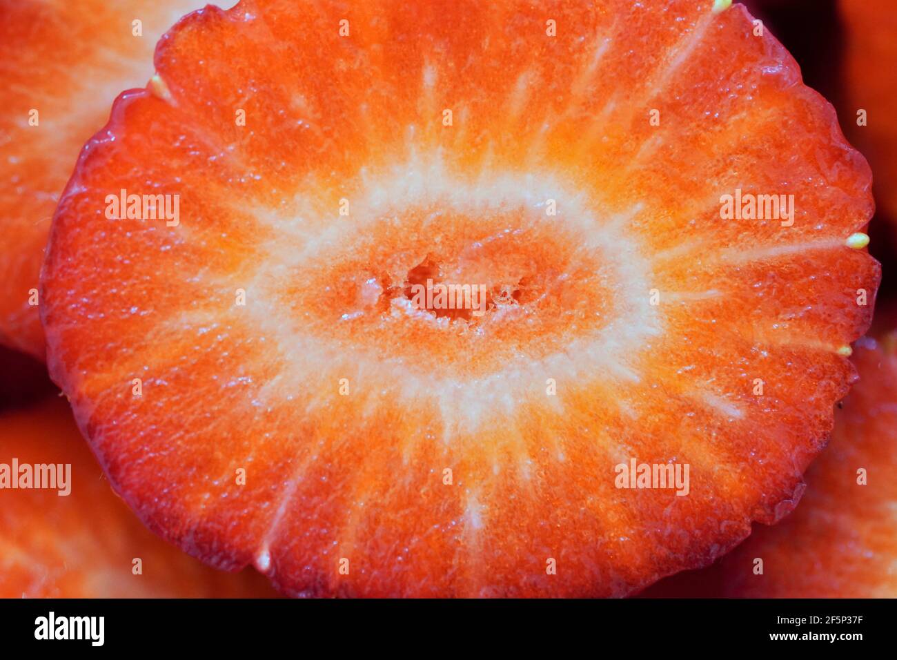 Nahaufnahme einer in Scheiben geschnittenen ​​red-Erdbeere. Makrofotografie von Früchten. Stockfoto