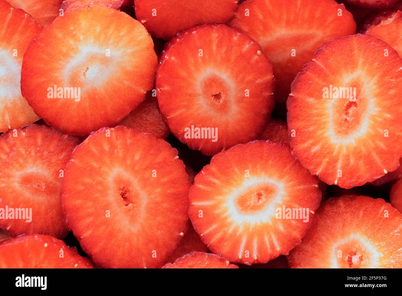 Nahaufnahme von in Scheiben geschnittenen ​​ripe-Erdbeeren. Frucht als roter Hintergrund. Gesunde Ernährung mit vielen Vitaminen Stockfoto
