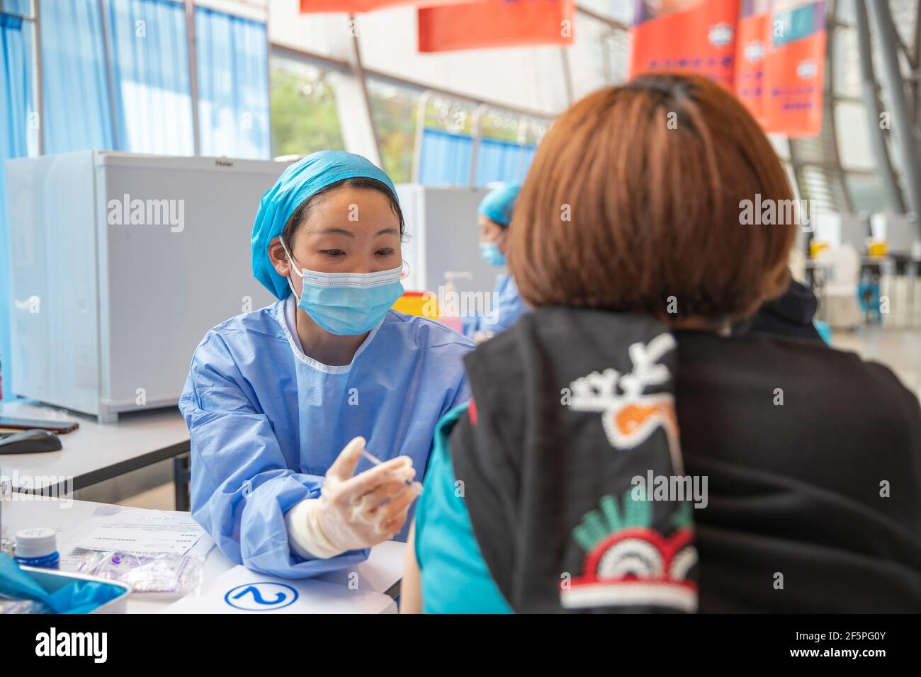 Chongqing, China. März 2021, 27th. Ein Bewohner erhält einen Schuss COVID-19-Impfstoff an einer temporären Impfstelle im Bezirk Nan'an in Chongqing, Südwestchina, 27. März 2021. In zwei Sportzentren im Bezirk Jiulongpo und im Bezirk Nan'an in Chongqing wurden zwei temporäre Impfstellen eingerichtet, die eine tägliche Impfkapazität von etwa 5.000 bzw. 10.000 haben. Quelle: Huang Wei/Xinhua/Alamy Live News Stockfoto