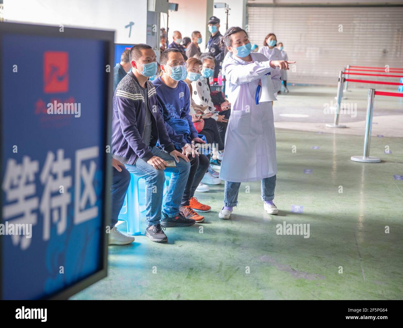 Chongqing, China. März 2021, 27th. Am 27. März 2021 warten die Menschen auf den Erhalt von COVID-19-Impfstoffen an einer temporären Impfstelle im Bezirk Jiulongpo in Chongqing, Südwestchina. In zwei Sportzentren im Bezirk Jiulongpo und im Bezirk Nan'an in Chongqing wurden zwei temporäre Impfstellen eingerichtet, die eine tägliche Impfkapazität von etwa 5.000 bzw. 10.000 haben. Quelle: Huang Wei/Xinhua/Alamy Live News Stockfoto