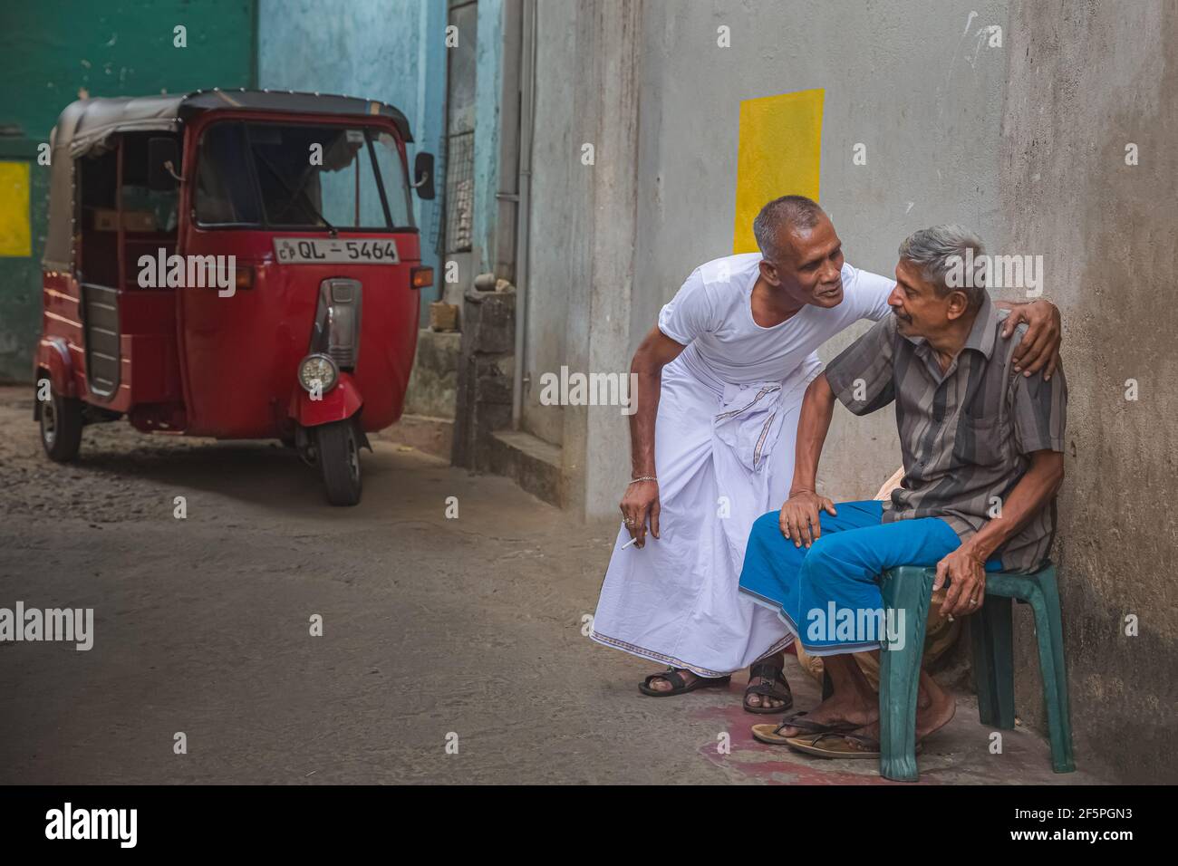 Kandy, Sri Lanka - März 21 2019: Ehrliches, freundliches Geplänkel zwischen zwei lokalen Sri-lankischen Männern, einer in einem weißen Kasaya, am Magha Puja Tag in Kandy, Sri Lan Stockfoto