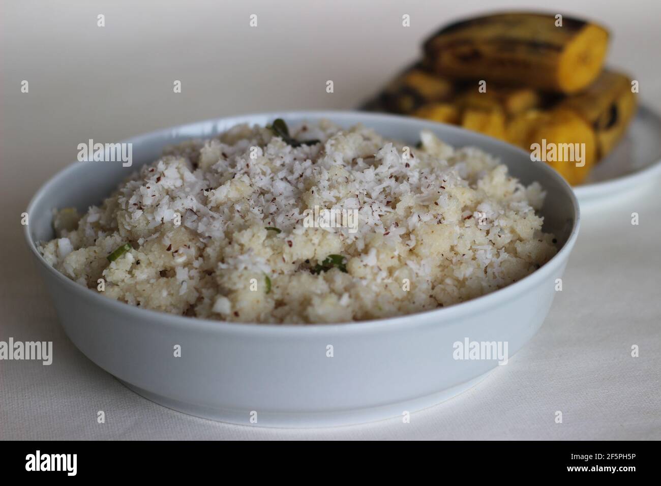 UPMA oder Uppuma ist ein gemeinsames südindisches und Sri Lanka tamilisches Frühstücksgericht, gekocht als dickes Haferflocken aus trockenem gebratenem Grieß oder grobem Reismehl Stockfoto