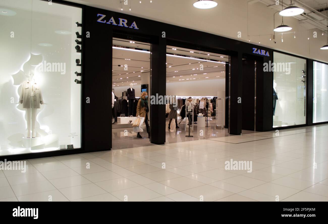 Moskau, Russland, Dezember 2020: Eingang zum Zara-Geschäft. Eine maskierte Kundin kommt mit ihren Einkäufen heraus. Stockfoto