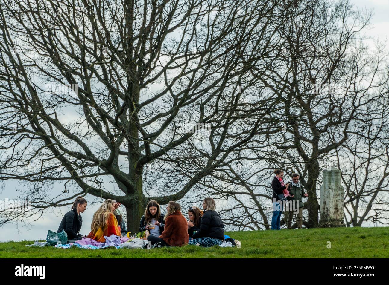 London, Großbritannien. März 2021, 27th. Die Menschen brechen bereits die 'Regel von 6' mit zwei Tagen, an denen nur noch eine andere Person außerhalb der Regel - hier in der Nähe des 'Stones der Redefreiheit' ein Treffpunkt versammelt ist. Schönes Wetter in Hampstead ermutigt Menschen, sich ein paar Tage vor der nächsten Etappe der Lockerung der Sperre 3 im Freien zu treffen. Kredit: Guy Bell/Alamy Live Nachrichten Stockfoto