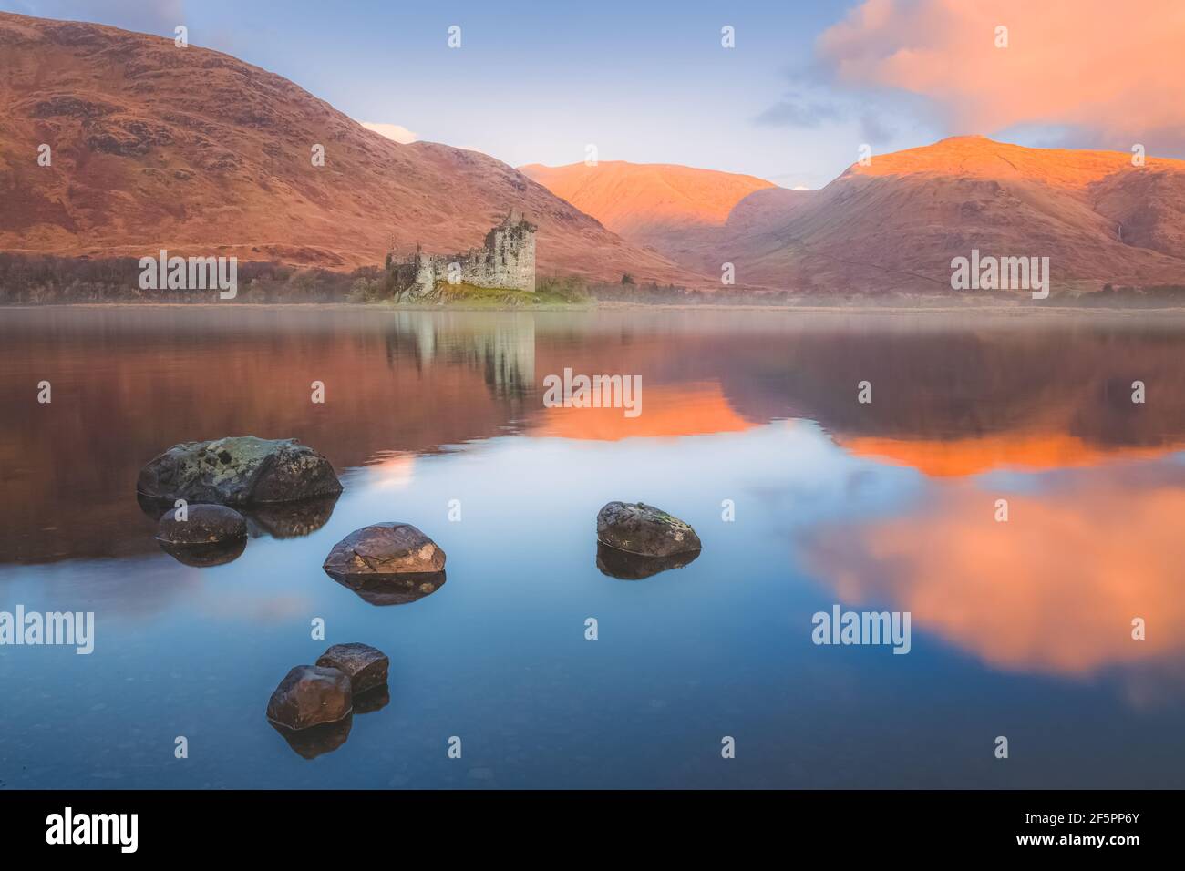 Schottische Highlands Landschaft der historischen Ruinen von Kilchurn Castle reflektiert auf einem ruhigen, friedlichen Loch Awe mit Sonnenuntergang oder Sonnenaufgang goldenes Licht. Stockfoto