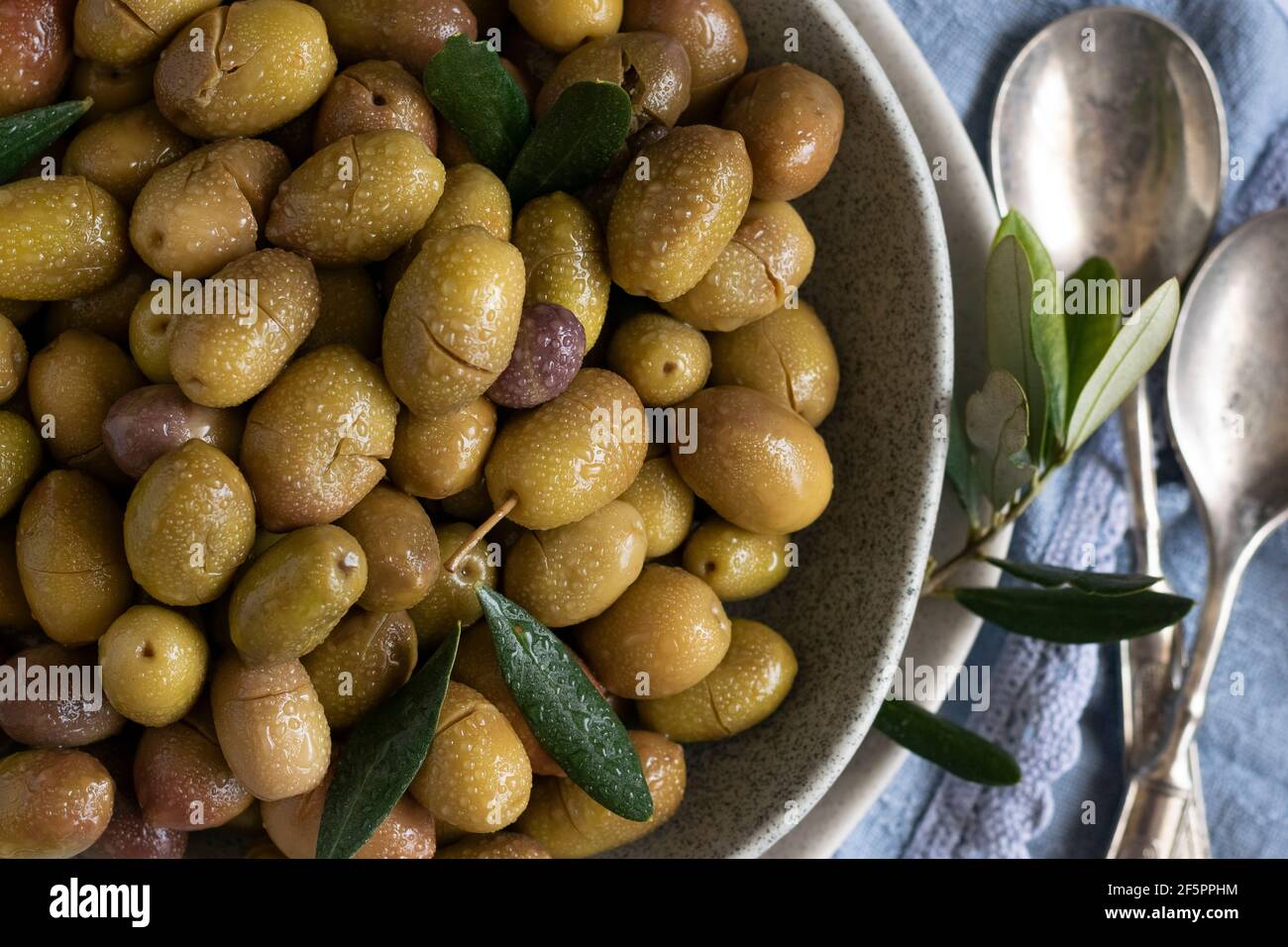Marinierte Oliven mit Kräutern und Gewürzen, gesunde natürliche Lebensmittelzutaten Stockfoto