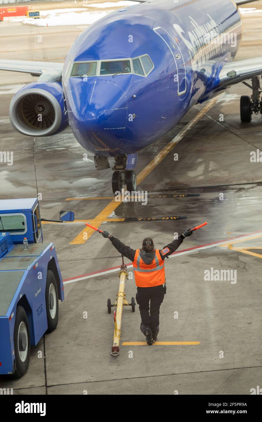 Denver, Colorado - ein Flugzeugmarschall leitet einen Southwest Airlines Jet, wenn er am Denver International Airport ankommt. Die Reise hat mit am zugenommen Stockfoto