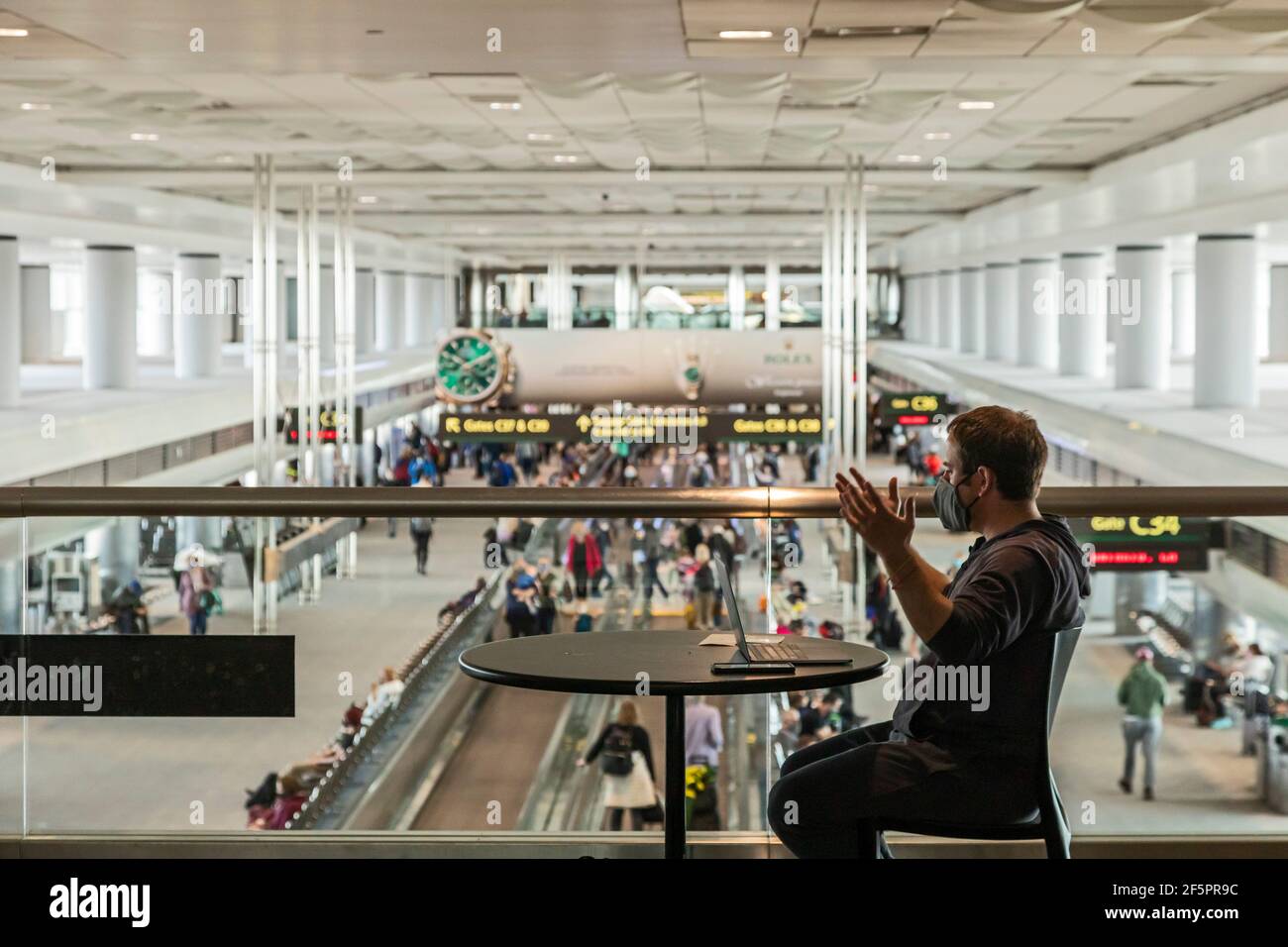 Denver, Colorado - EIN Passagier arbeitet, während er auf sein Flugzeug am Denver International Airport wartet. Reisen hat mit Amerikaner 'Hoffnung, dass die c erhöht Stockfoto