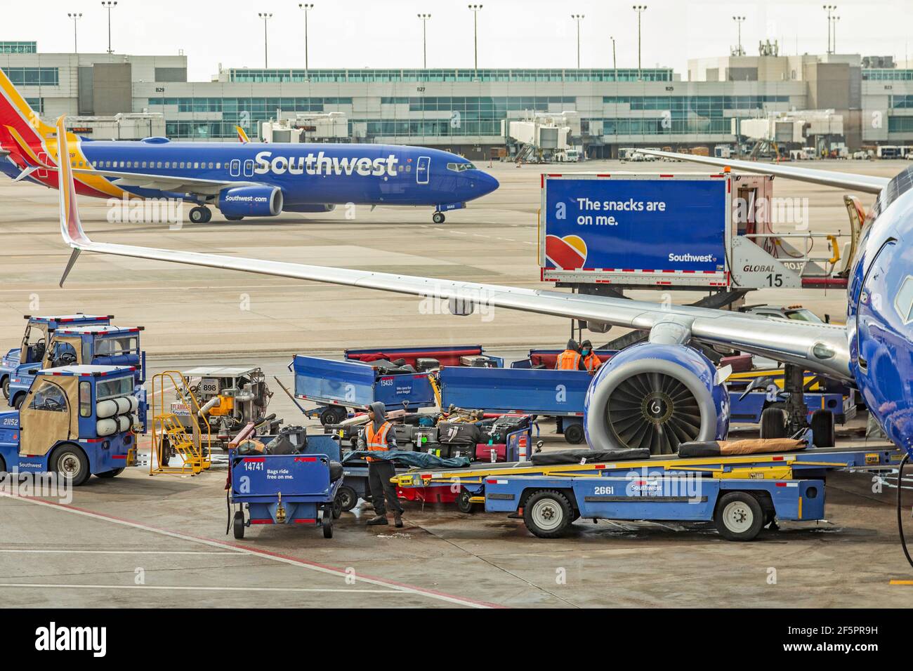 Denver, Colorado - Mitarbeiter des Bodenpersonals warten einen Jet von Southwest Airlines nach seiner Ankunft am Denver International Airport. Reisen hat mit zugenommen Stockfoto