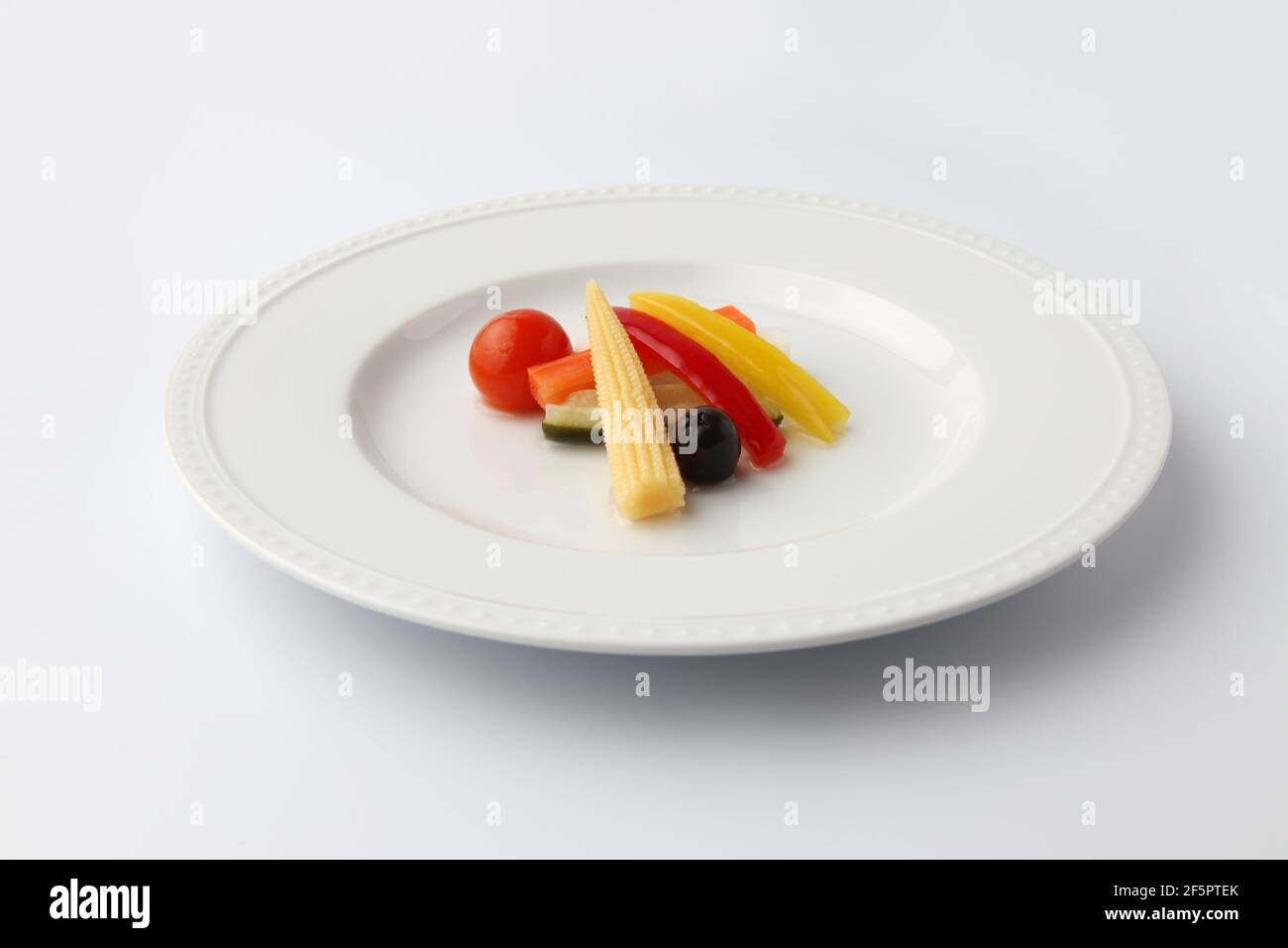 Gurken eingelegter Gemüsesalat auf Teller isoliert auf weißem Hintergrund Stockfoto