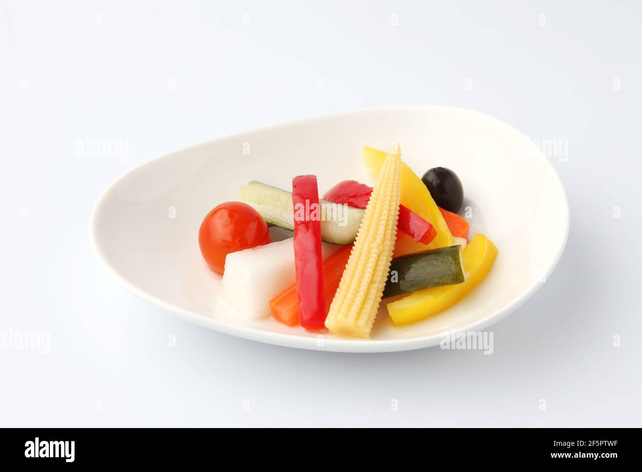Gurken eingelegter Gemüsesalat auf Teller isoliert auf weißem Hintergrund Stockfoto