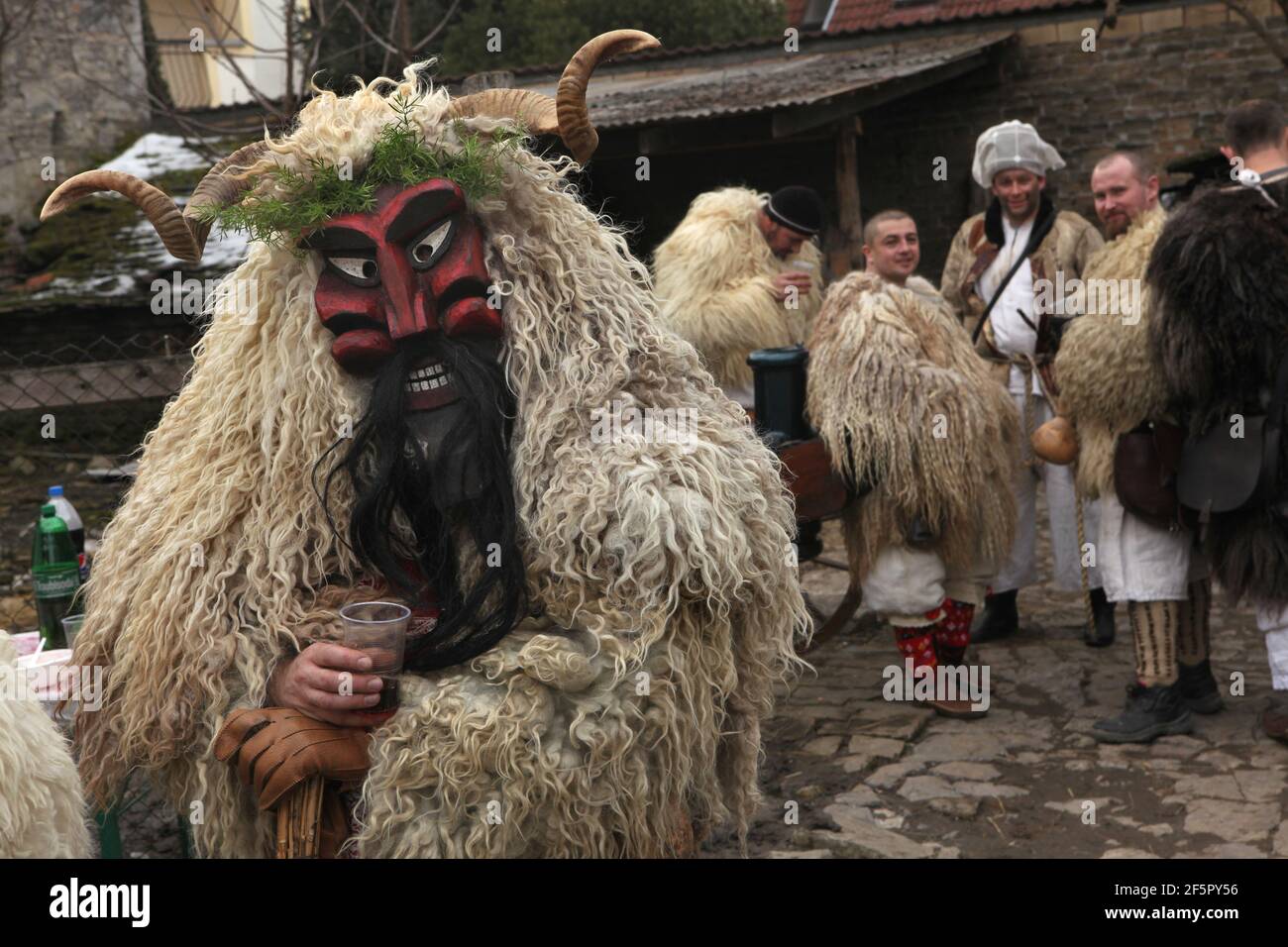 Maskierte Busós Bereiten Sie sich auf die Karnevalsprozession im Hof eines der Häuser in der Innenstadt am Farsang Dienstag während des Busójárás Karneval in Mohács in Baranya County, Ungarn. Traditionelle jährliche maskierte Feier der ethnischen Gruppe Šokci am Ende der Karnevalssaison (Farsang) in Südungarn. Stockfoto